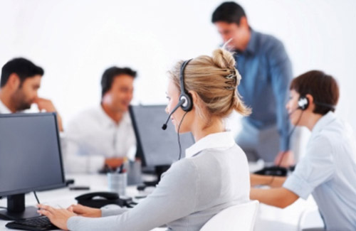 Woman with headset in front of computer in a call center